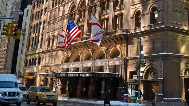 Carnegie Concert Hall in Manhattan, New York with snow on the sidewalk and cars on the streets, carnegie hall performance tours